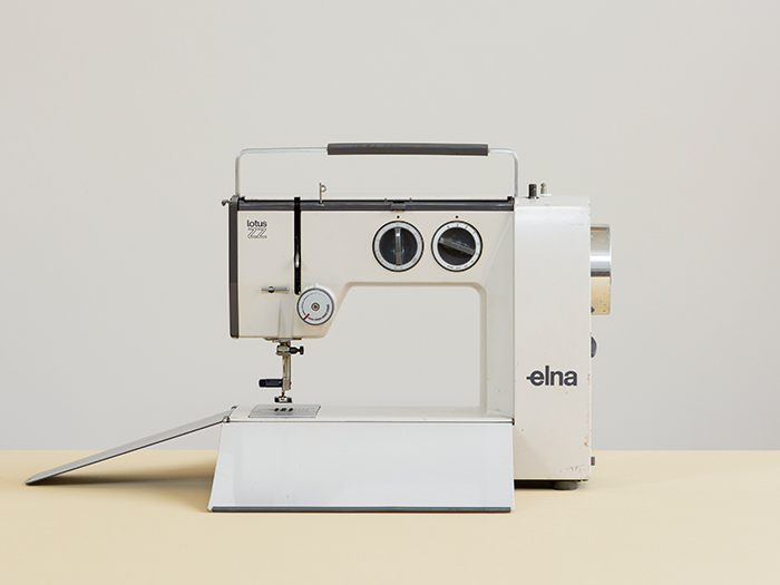 Photo of Elna Lotus ZZ sewing machine c.1968-1977 in white with black and silver detail on cream surface and grey background