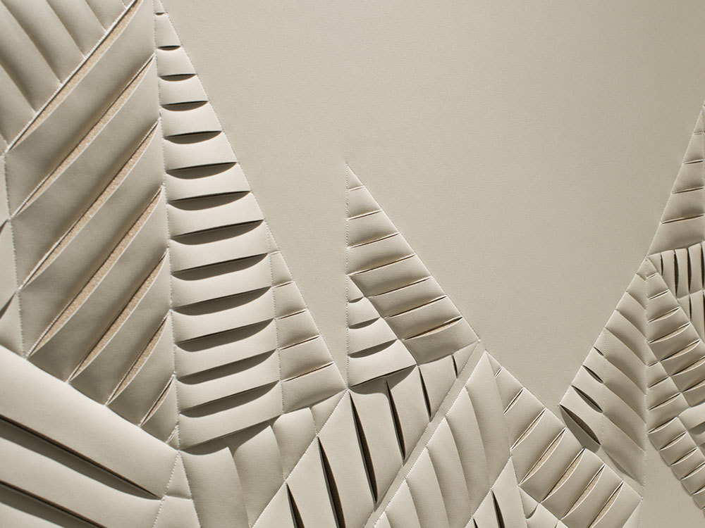 Detail of hand-sculpted artwork by Helen Amy Murray featuring an abstract New York City Skyline in taupe faux leather