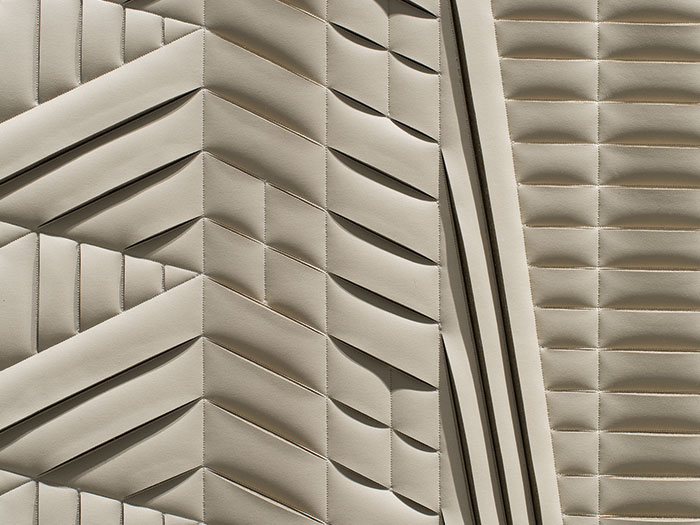 Detail of hand-sculpted artwork by Helen Amy Murray featuring an abstract New York City Skyline in taupe faux leather