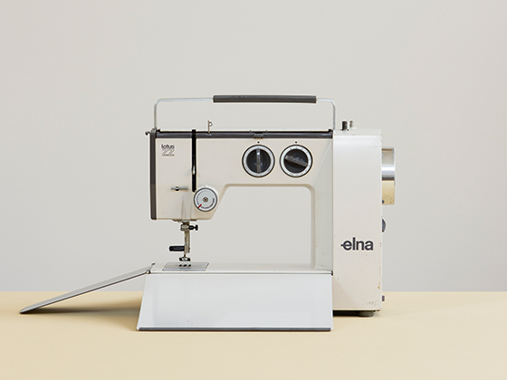 Photo of Elna Lotus ZZ sewing machine c.1968-1977 in white with black and silver detail on cream surface and grey background
