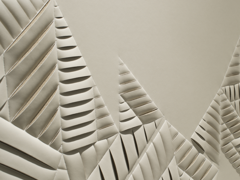 Detail of hand-sculpted artwork by Helen Amy Murray featuring an abstract New York City Skyline in taupe faux leather