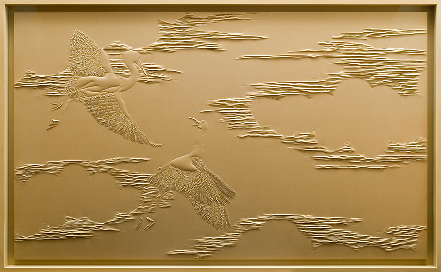 Detail of hand-sculpted gold faux suede artwork by Helen Amy Murray featuring cranes and clouds in a gold wooden frame