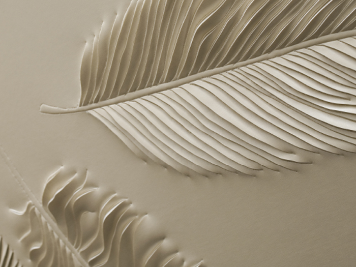 Detail of hand-sculpted artwork with feathers in cream faux leather