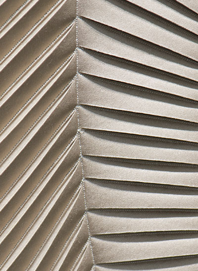 Detail of hand-sculpted artwork with herringbone design in taupe faux suede with taupe colour silk crepe satin