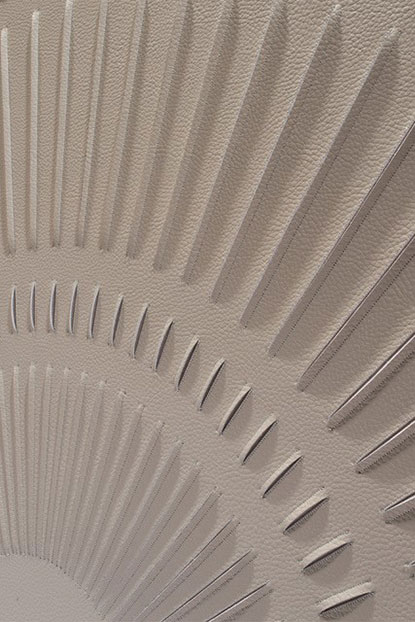 Detail of Radial artwork by Helen Amy Murray, seen from the side with diagonal hand sculpted lines in taupe faux leather